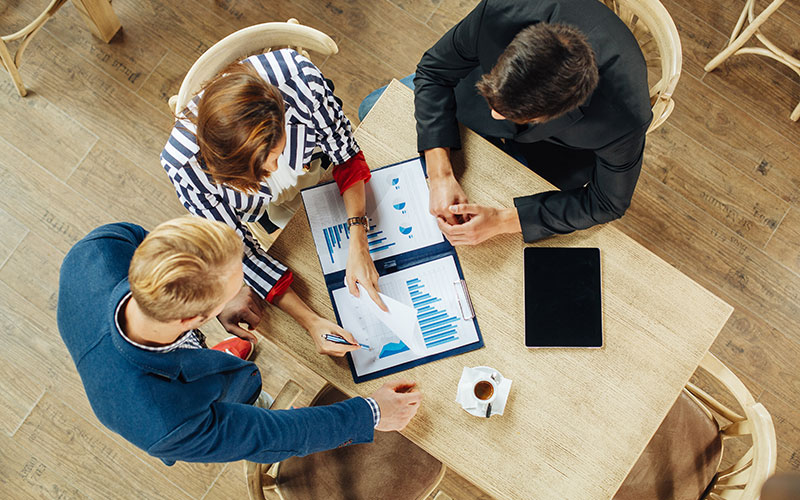 Three people working around a table