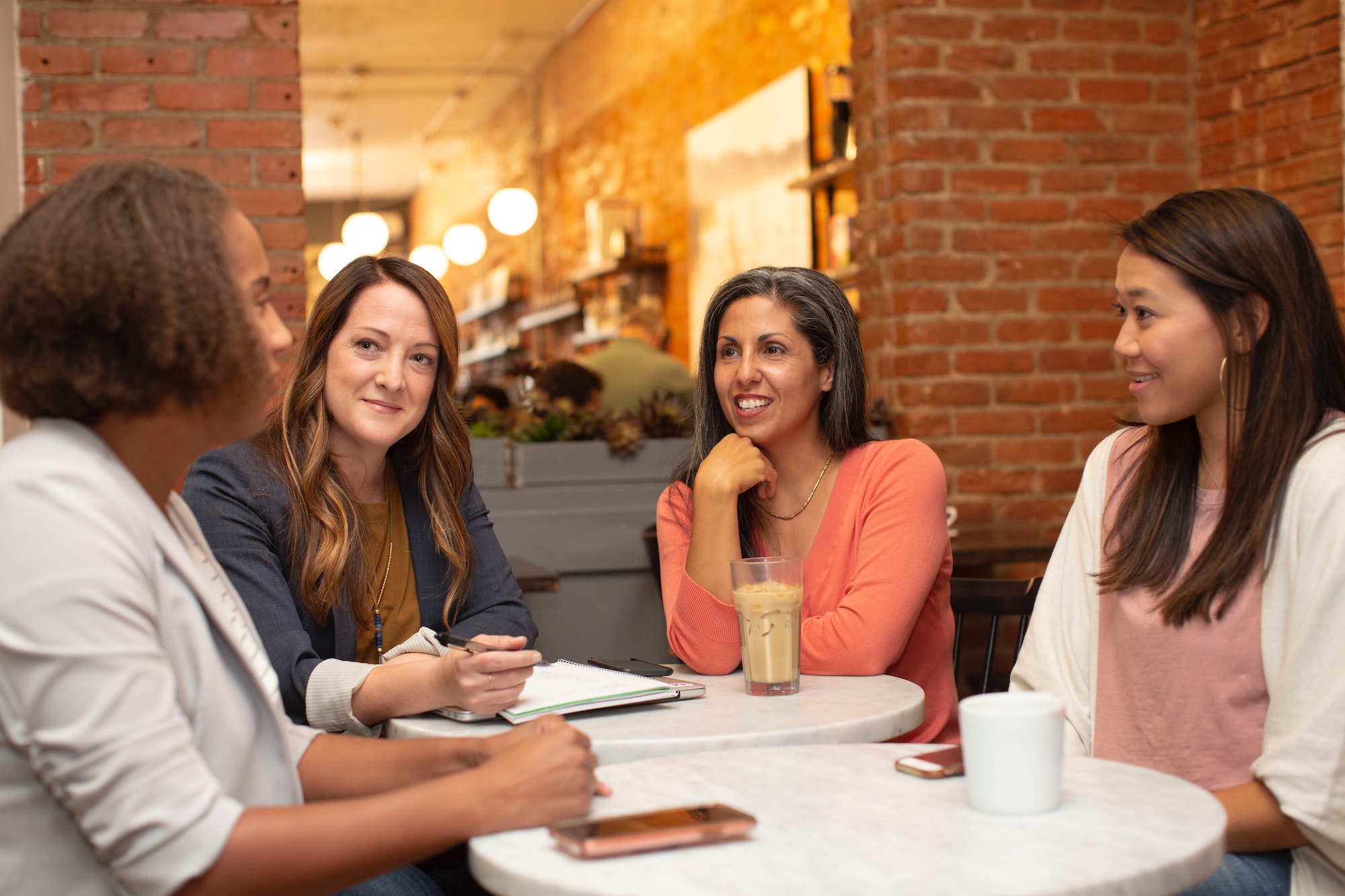 women strategic leadership meeting sitting around table discussing business